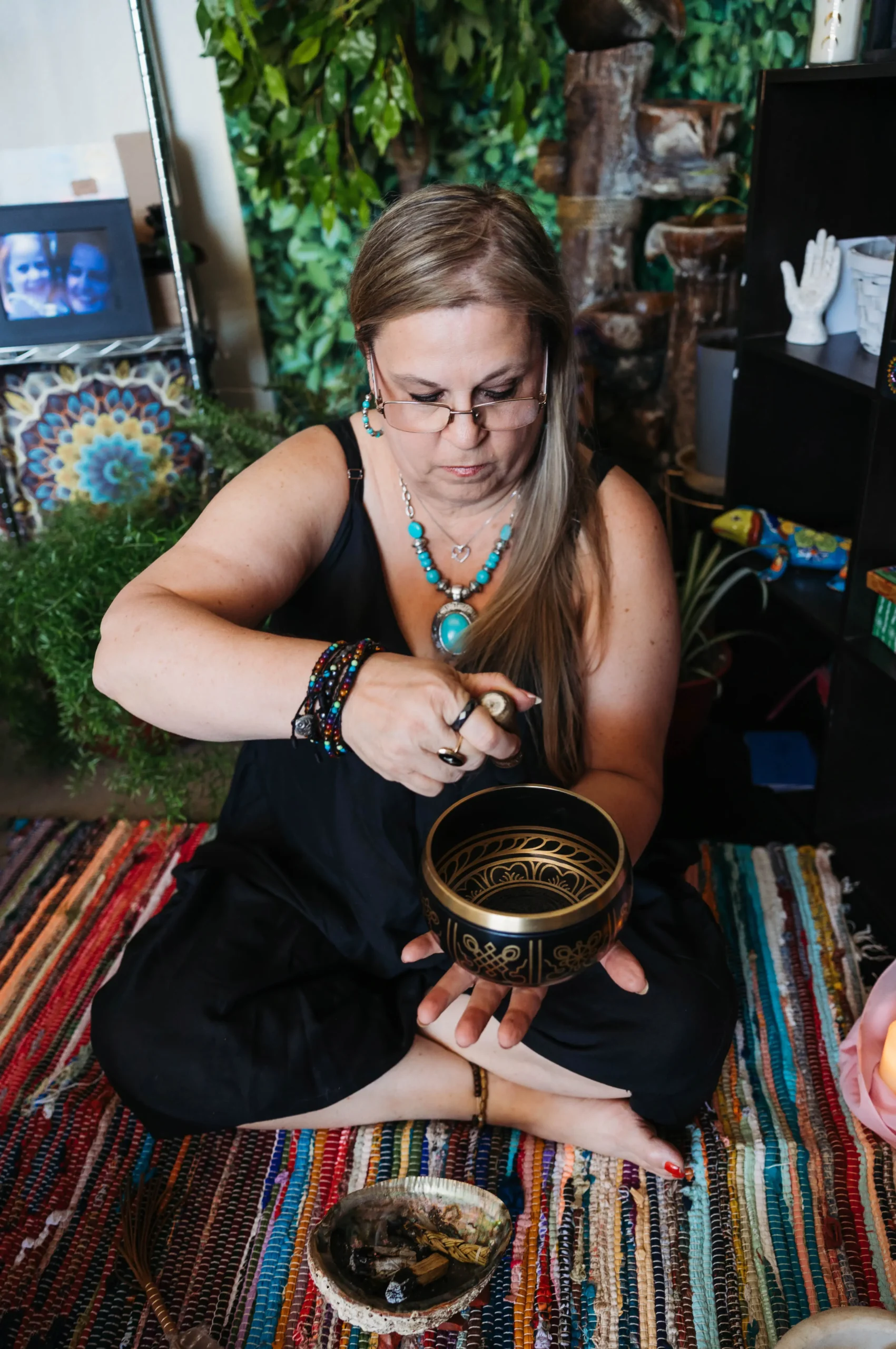 AO5A0529 A woman sits on the floor, enjoying a bowl of food, with a relaxed expression and a cozy atmosphere around her.